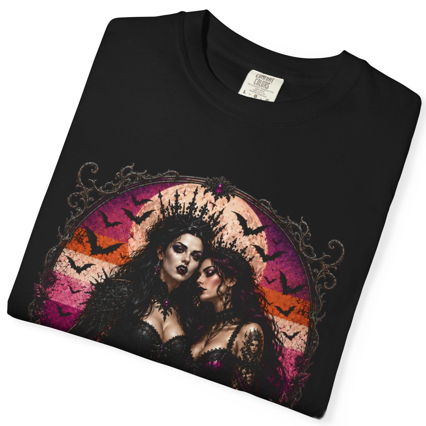 A folded black short-sleeve t-shirt with a gothic-style graphic print of two women, bats, and a pink and orange circular background, shown on a white background.