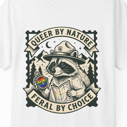 A white short-sleeve t-shirt featuring a large graphic print of the raccoon Jimothy dressed as a park ranger holding a map, with the text 'QUEER BY NATURE' and 'FERAL BY CHOICE'.