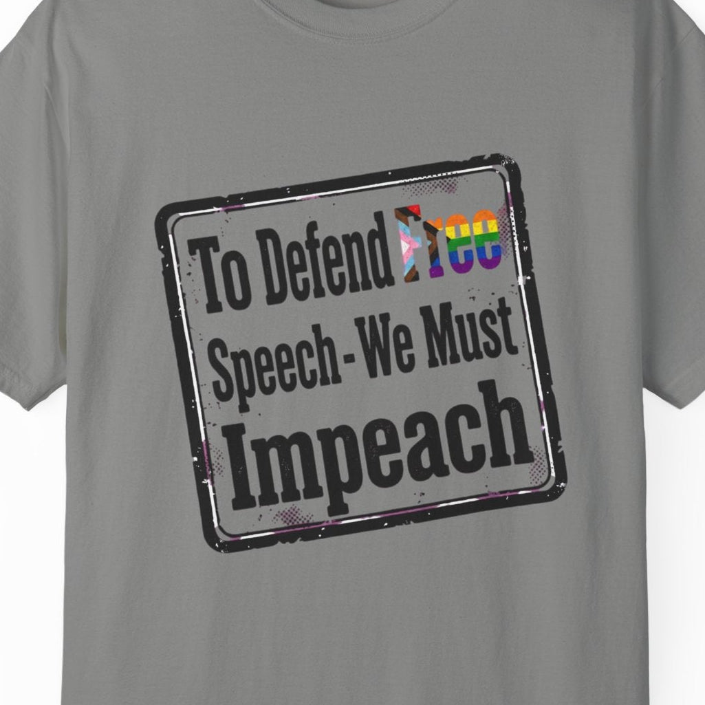 A gray short-sleeve t-shirt with a distressed rectangular graphic on the chest that reads 'To Defend Free Speech-We Must Impeach' in black text, featuring a small LGBTQ rainbow flag accent.