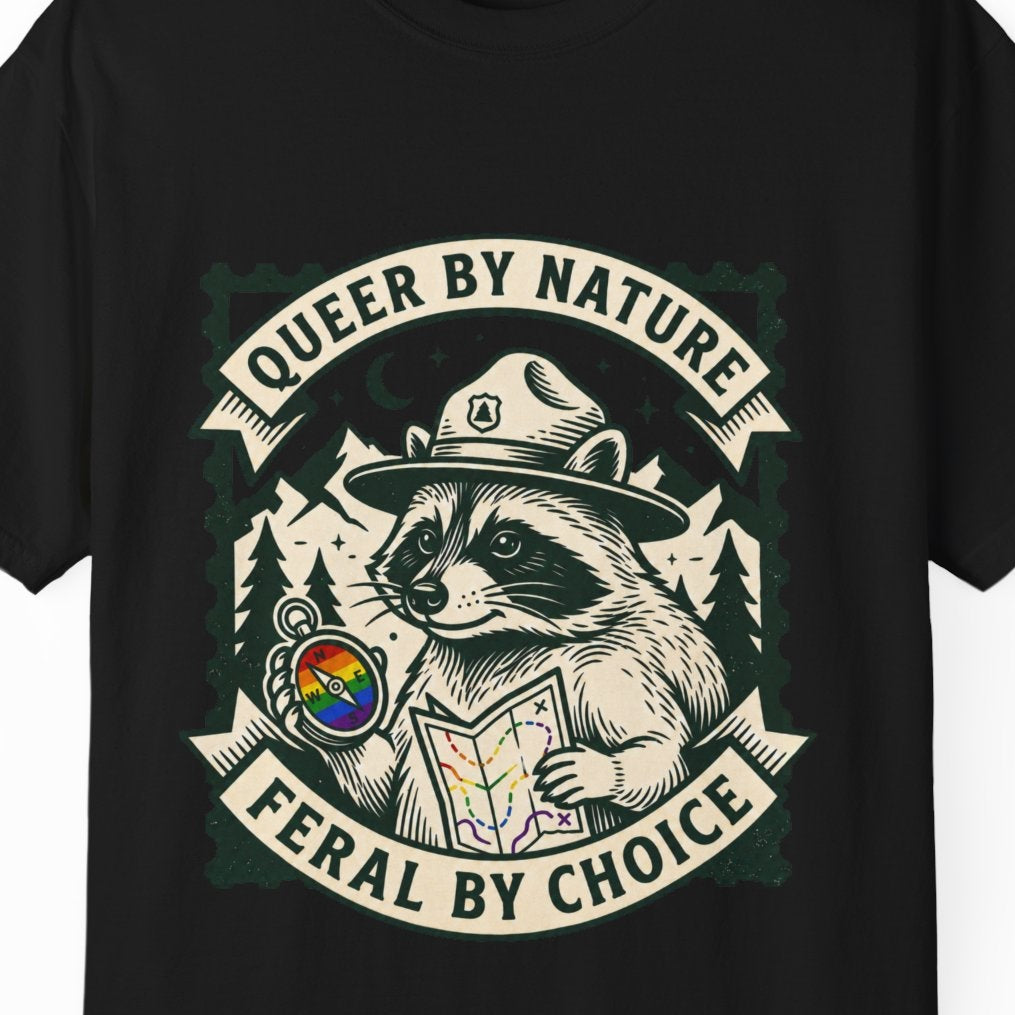 A black short-sleeve crewneck t-shirt featuring a vintage-style graphic of the raccoon Jimothy wearing a ranger hat and holding a map, surrounded by the text 'QUEER BY NATURE' and 'FERAL BY CHOICE' with a small rainbow flag detail.