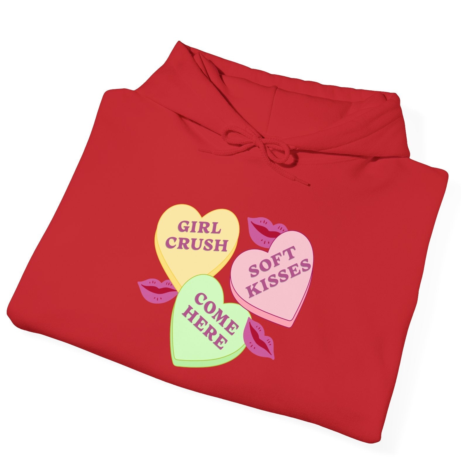 Folded red hoodie with colorful candy heart graphics on a white background