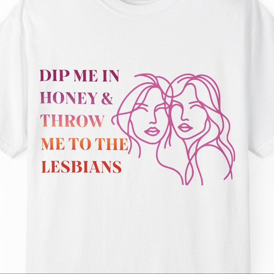 Gay pride t-shirt featuring Dip Me in Honey & Throw Me to the Lesbians design in lesbian flag colors with line drawing of two lesbians by Queer Energy in white