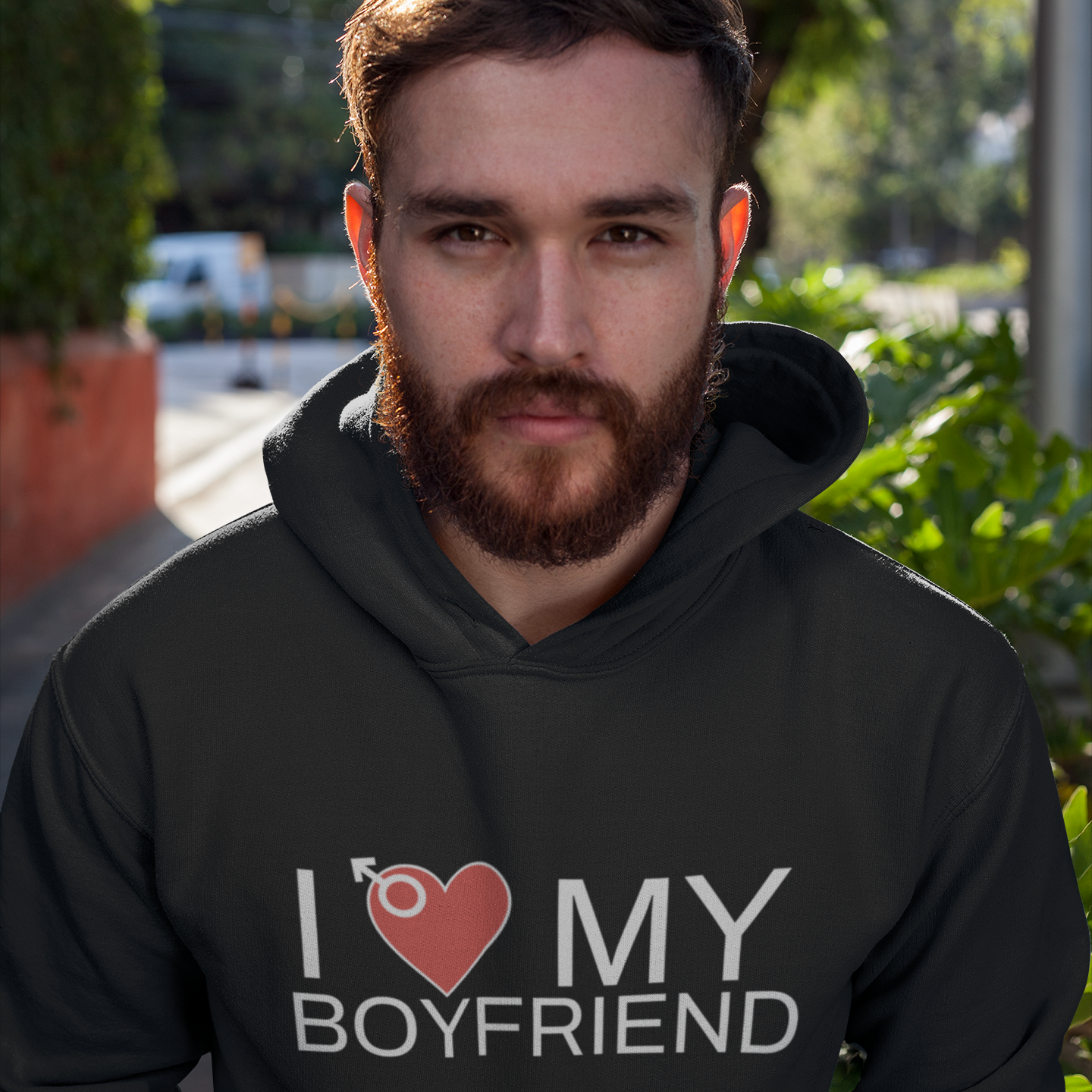 Gay Man wearing a black hoodie with 'I ❤️ MY BOYFRIEND' text outdoors.
