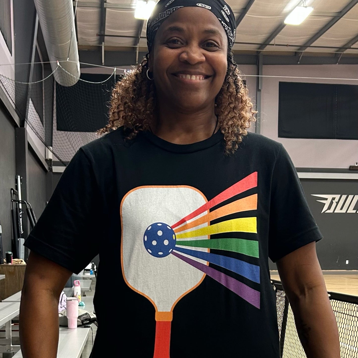 Lesbian wearing a black Pickleball t-shirt with lgbtq rainbow