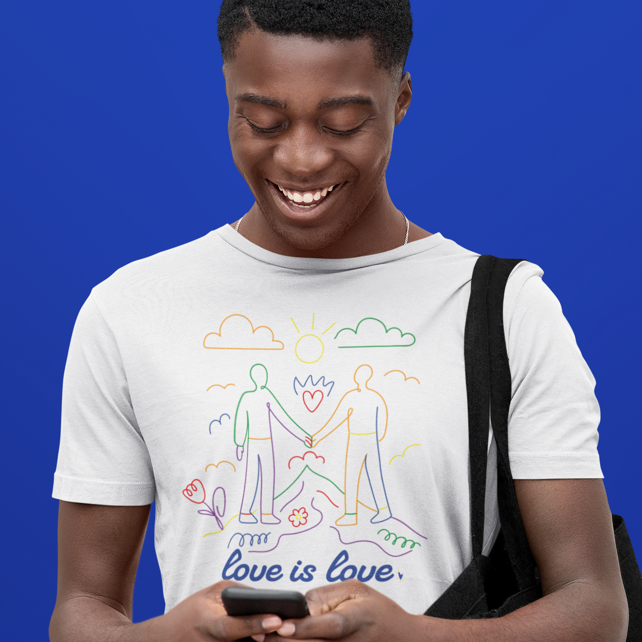 Gay Man wearing a 'Love is Love' t-shirt against a blue background