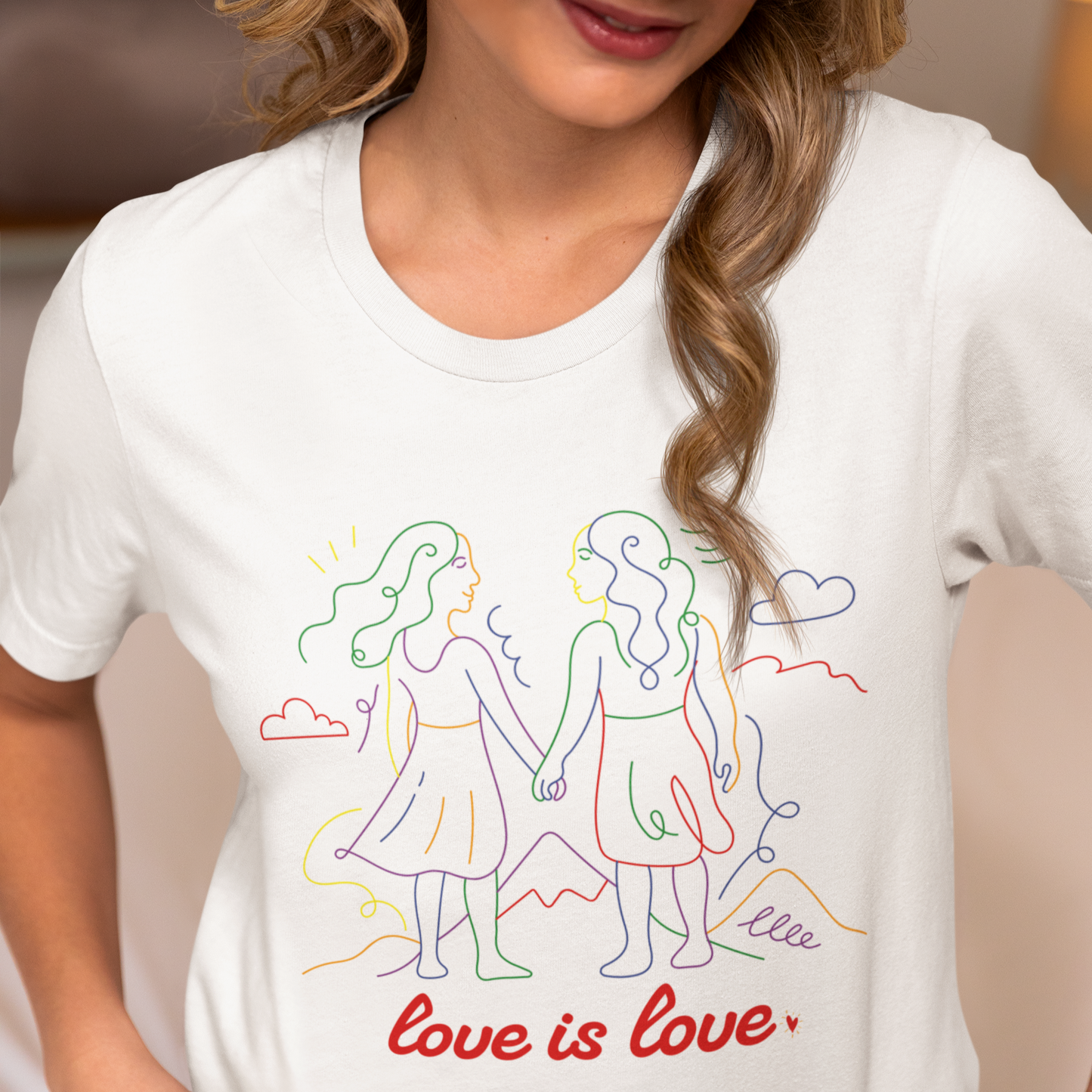 Mockup of lesbian wearing a white Gay pride t-shirt featuring Love is Love lesbian doodle design in rainbow colors by Queer Energy
