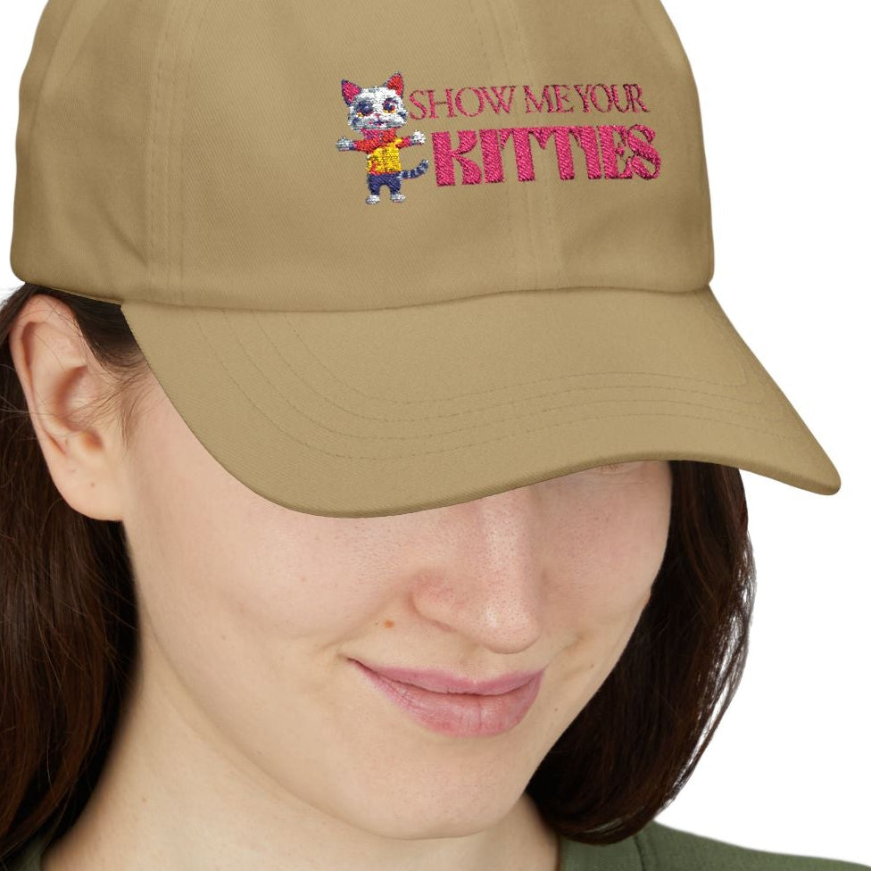 Lesbian wearing a tan cap with embordered text that says, "Show me your Kitties" and graphics on a white background