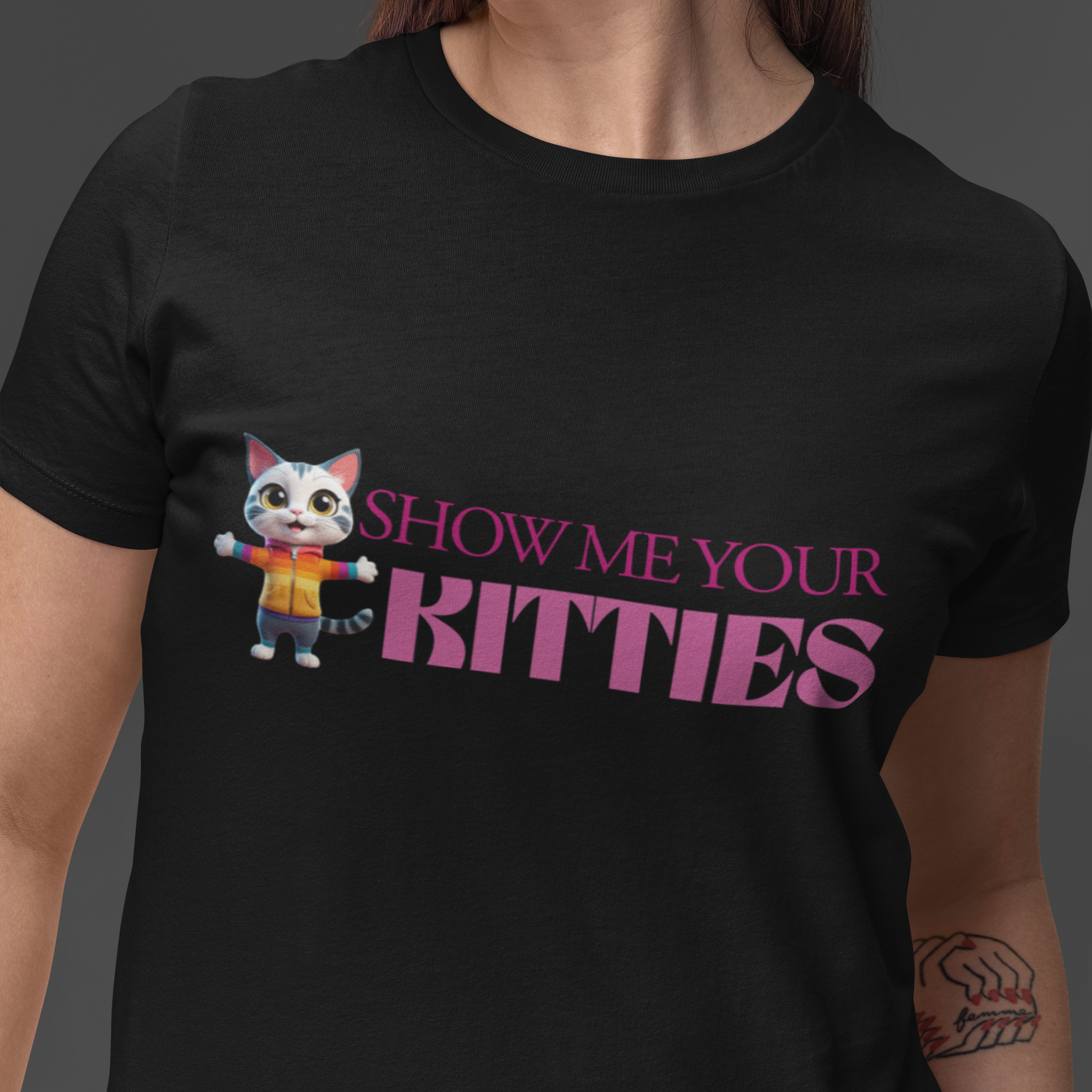 Sapphic wearing a black t-shirt with a cartoon cat that says "SHOW ME YOUR KITTIES" in Lesbian flag colors
