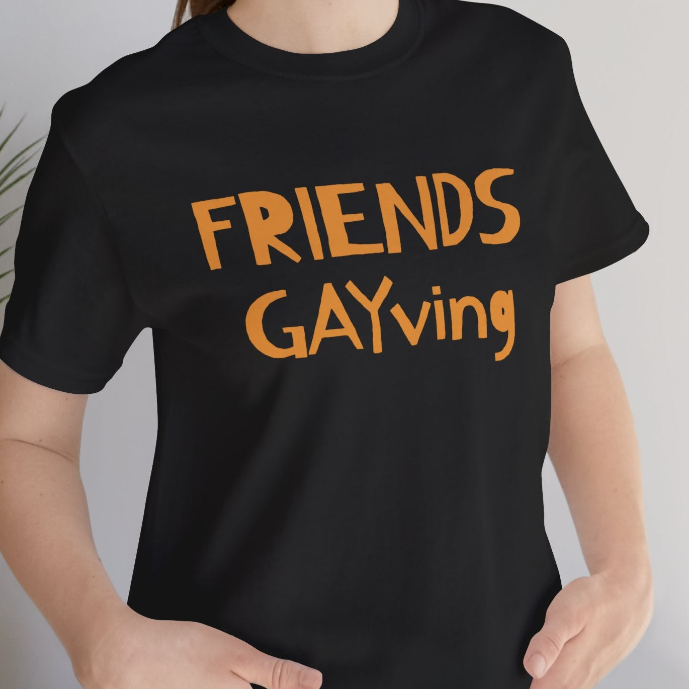 mockup of lesbian wearing a black Gay pride t-shirt featuring Friends Gayving design for funny LGBTQ+ Thanksgiving – Designed by Queer Energy