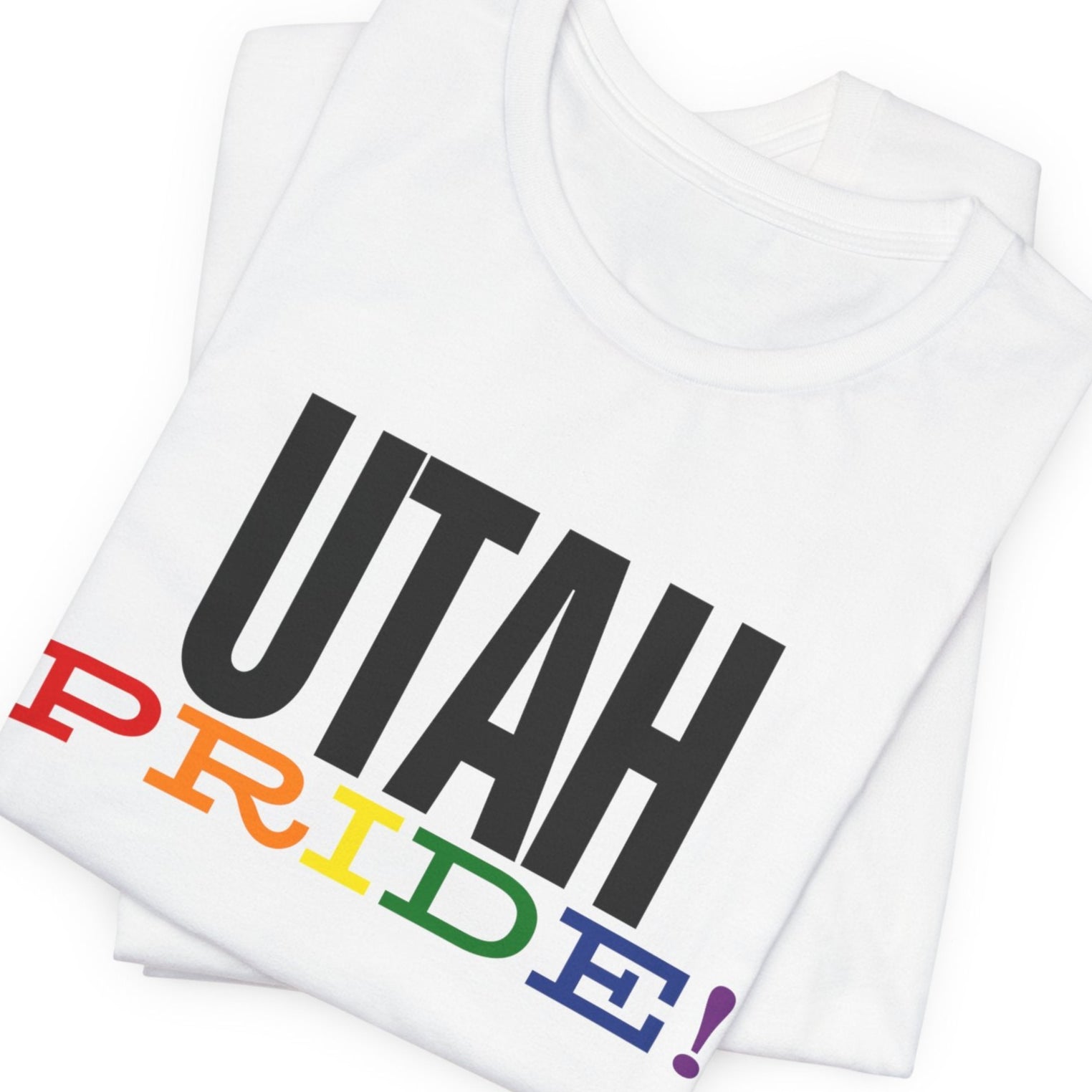 mockup of white folded Gay pride t-shirt with bold "UTAH PRIDE" text in rainbow colors – Designed by Queer Energy