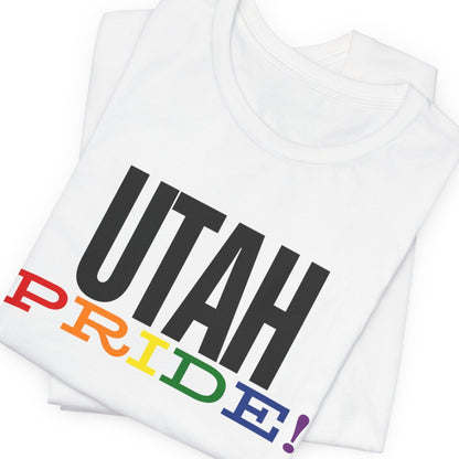 mockup of white folded Gay pride t-shirt with bold "UTAH PRIDE" text in rainbow colors – Designed by Queer Energy